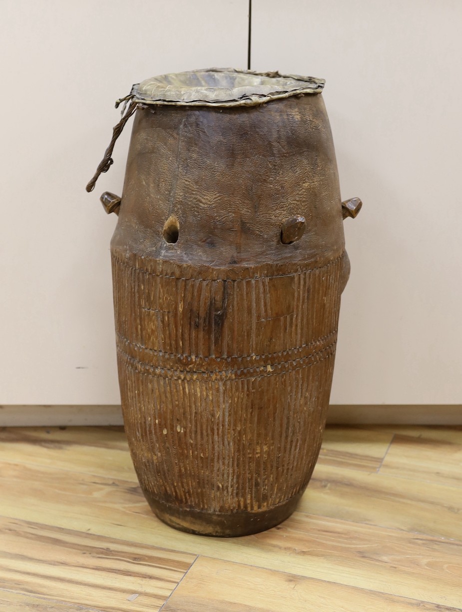 A 19th/20th century Ashanti breasted drum, 61 cms high.